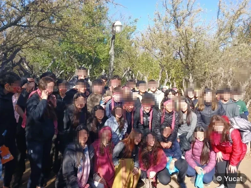 Un grupo numeroso de estudiantes con pintura facial, posando juntos al aire libre.