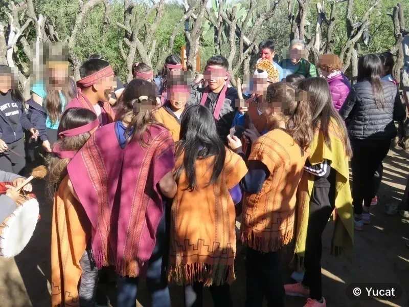 Un grupo de adolescentes con vinchas y ponchos, reunidos en ronda durante una actividad grupal.
