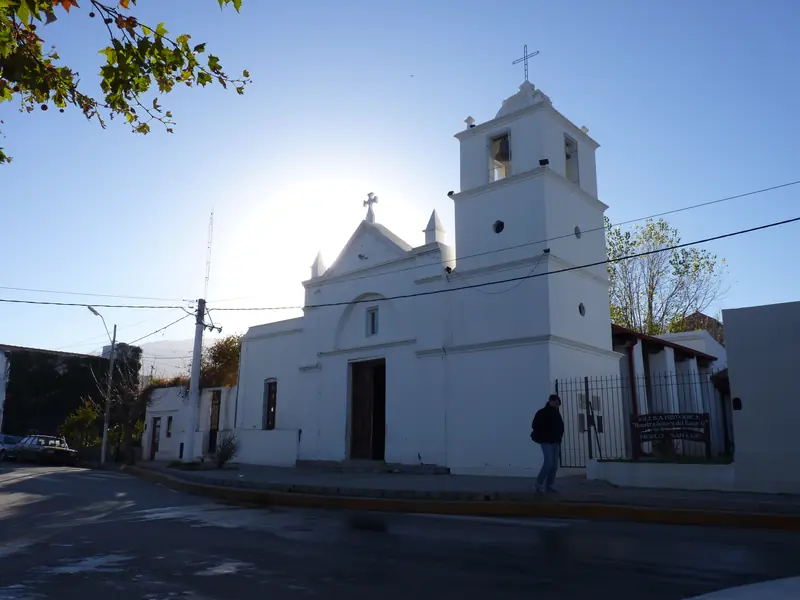 Fachada blanca de la Iglesia Histórica Nuestra Señora del Rosario, frente a la plaza de Merlo.