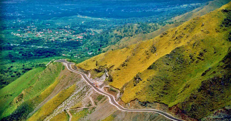 Camino de cornisa del Filo Serrano descendiendo hacia el valle, con Villa de Merlo de fondo.