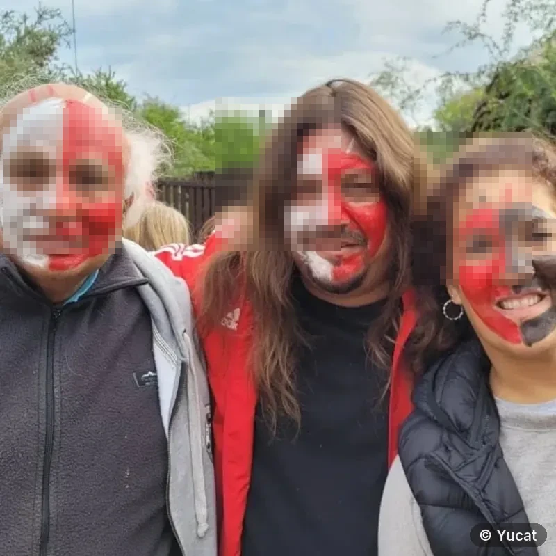 Tres adultos con la cara pintada de rojo, blanco y negro en un diseño de guerra.